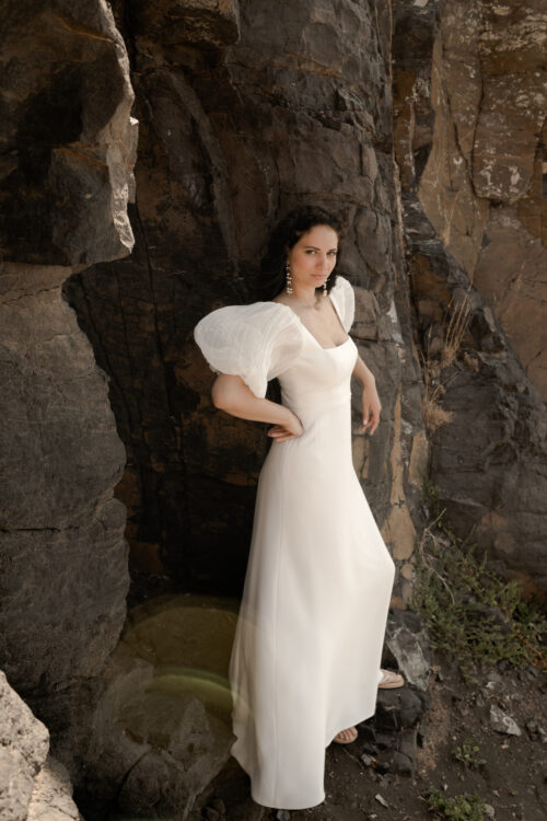 POWERFUL est une robe de mariée chic en crêpe de soie avec des manches bouffantes en mousseline de soie plissée. Son décolleté carré conviendra parfaitement aux filles qui cherchent une robe de mariée pour forte poitrine. Bijoux @anthemis.paris